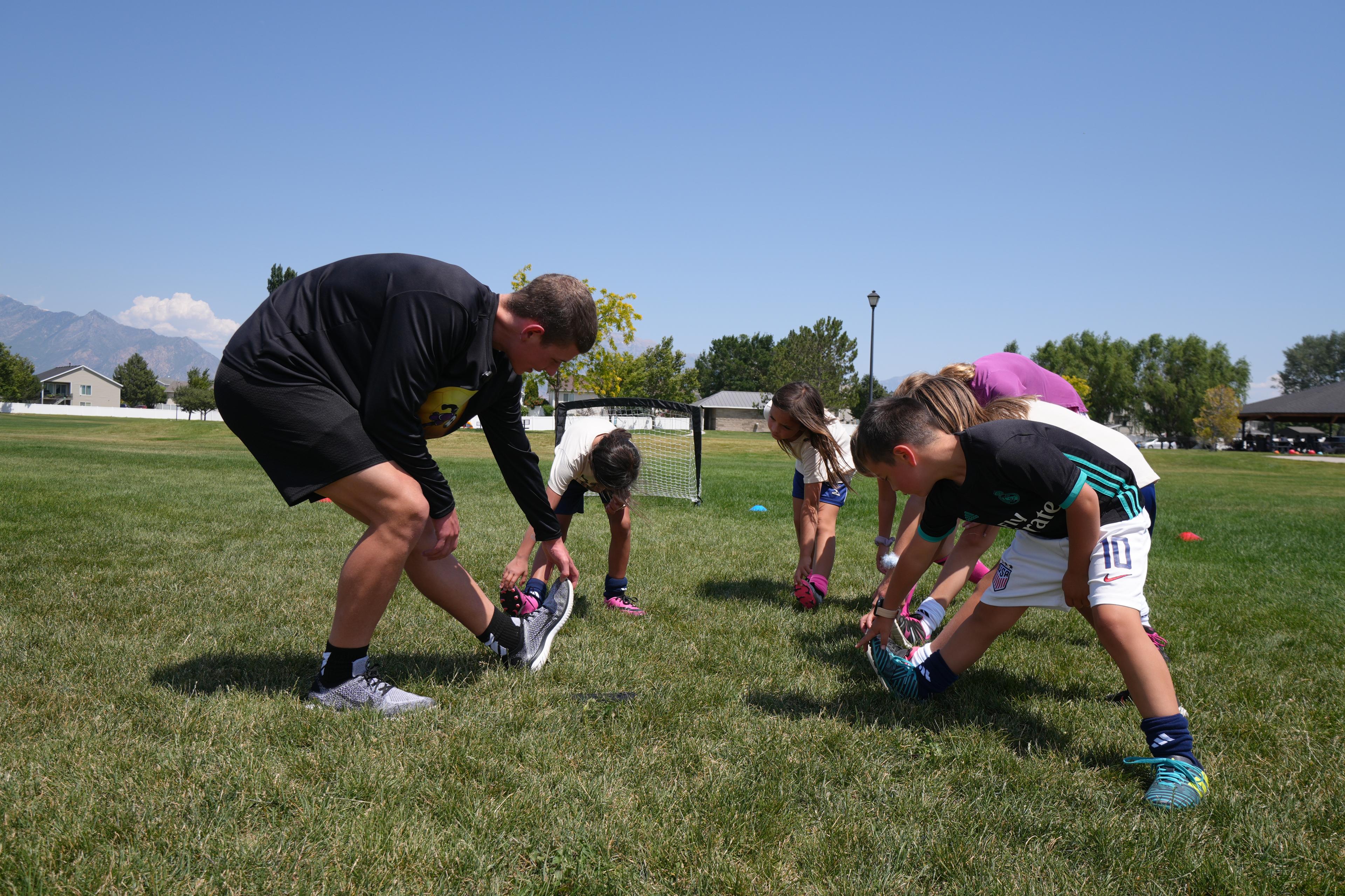 Coach leading structured warmup stretching before training